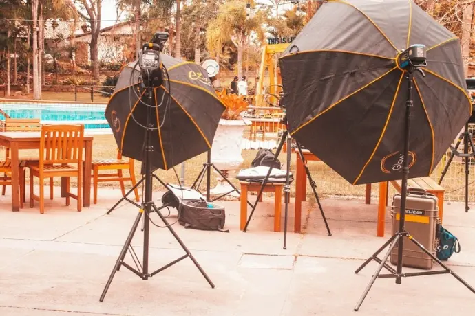 Behind the scenes swimwear photoshoot setup with lighting equipment near a pool Sansaq Design
